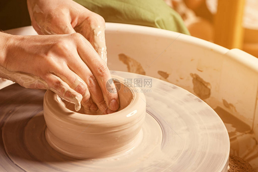 近身女陶匠雕刻着深层棕色粘土板在车间图片