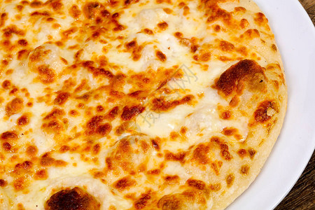 木制背景上的热美味奶酪披萨图片