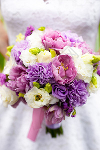 美女新娘拿着白花粉红花和紫花的彩图片