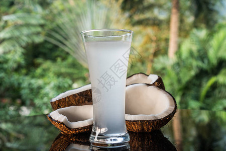黑玻璃桌上的椰子和椰子水紧闭背景图片