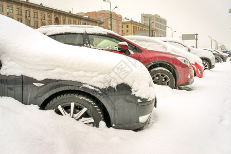 停车场上的街道上被雪覆盖的汽车图片