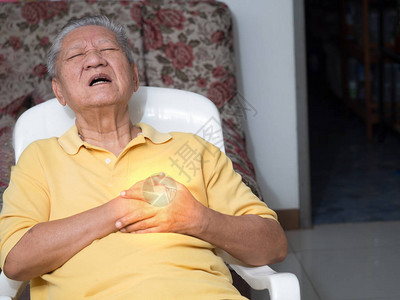 老年亚洲男子坐在的椅子上心脏病发作图片