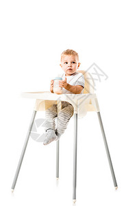 可爱的小孩男拿着婴儿瓶子坐在高椅子上图片