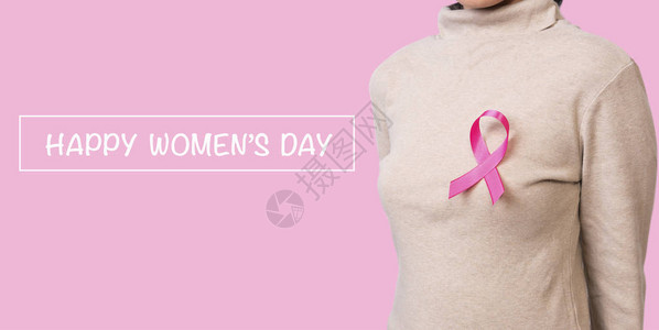 胸前系着粉红丝带的女人支持乳腺癌意识和国际妇女图片