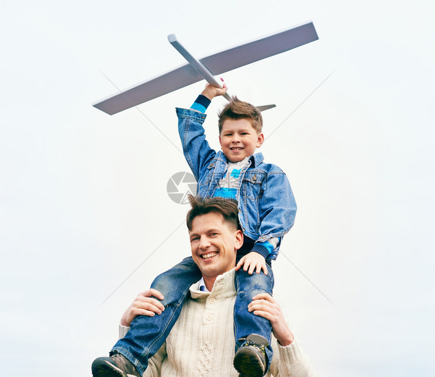 照片快乐的男孩与玩具飞机和他父亲图片