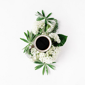 黑色咖啡杯和白色花朵束图片