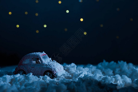 午夜在星空下站在雪中的玩具车近距离拍图片