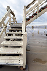白色楼梯飞向海滩上一个救生员小屋的宽角景象图片