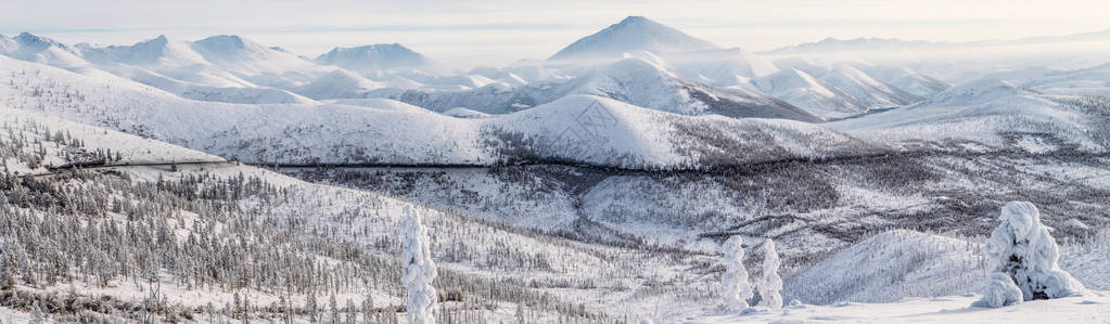 美丽的雪覆盖了冬季道路和在雪盖山的树木科利马高速公路图片