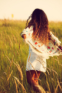 穿着波霍风格服装的女子在草丛中奔跑炎热的夏日复古颜图片
