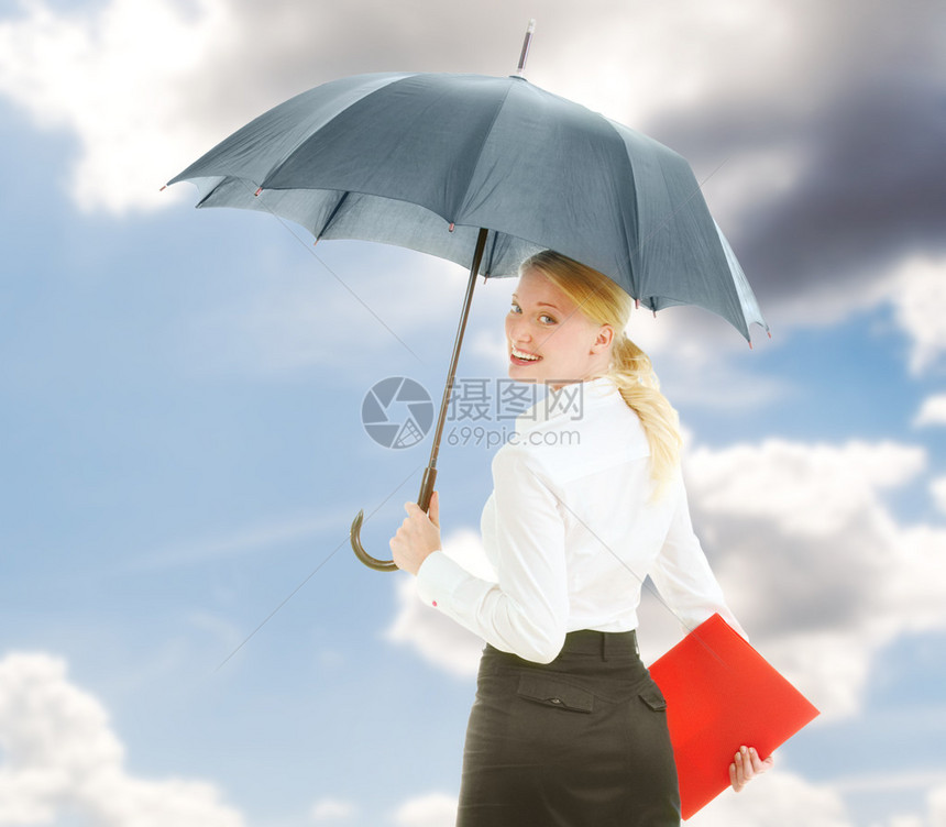 快乐的女商人在开放的伞下图片