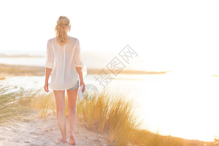 在美丽的沙滩上享受自由和生活的年轻女人图片
