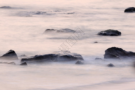 早晨海滩有石头波浪图片