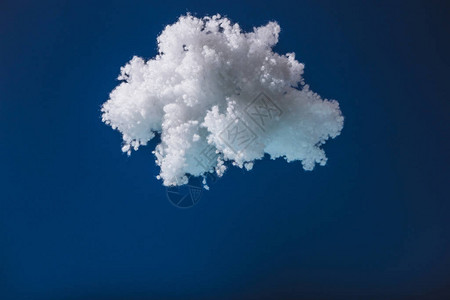 由棉绒制成的白色蓬松云在深蓝色上隔开背景图片