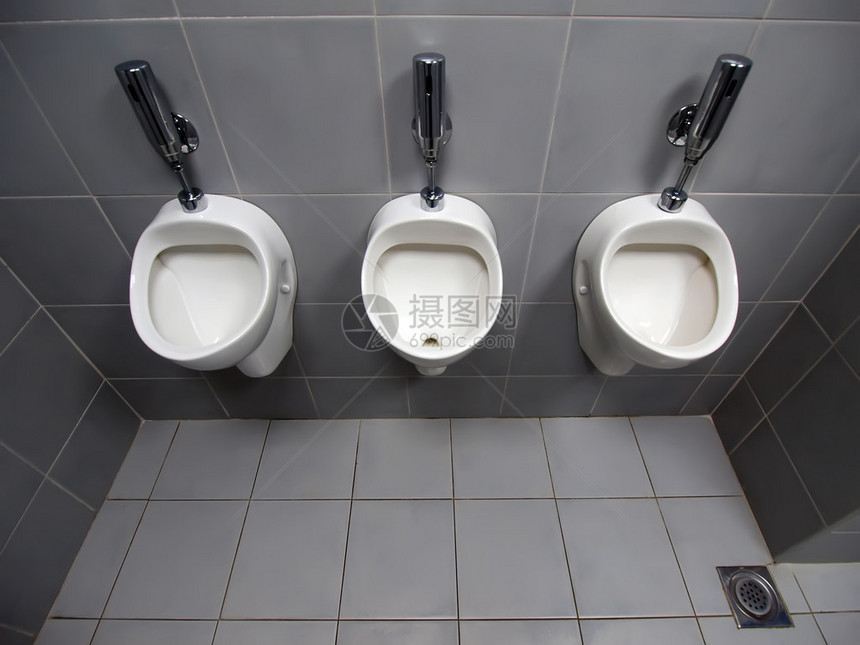 3个白色自动陶瓷小便放在公共厕所灰图片