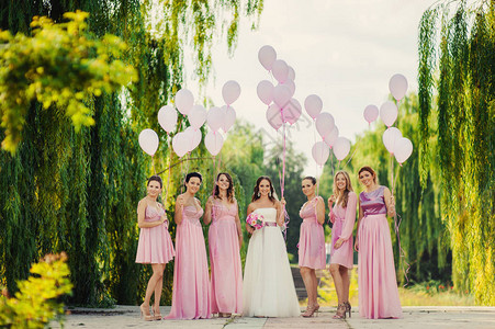 新娘和伴娘穿着粉红色连衣裙散步图片