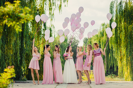 新娘和伴娘穿着粉红色连衣裙散步图片