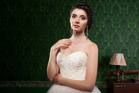 美丽的新娘在工作室照片中的绿色复古图案背景刚结婚华丽的背景图片