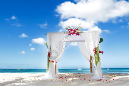 海滩上用鲜花装饰的婚礼拱门图片