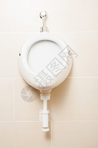 白色陶瓷小便池在男人的浴室里在图片