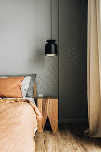 卧室配有床姜床罩枕头橡木床头柜设计师吊灯木地板图片