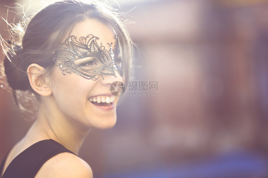 带着黑色化妆面具的年轻美貌女子的快乐面容图片