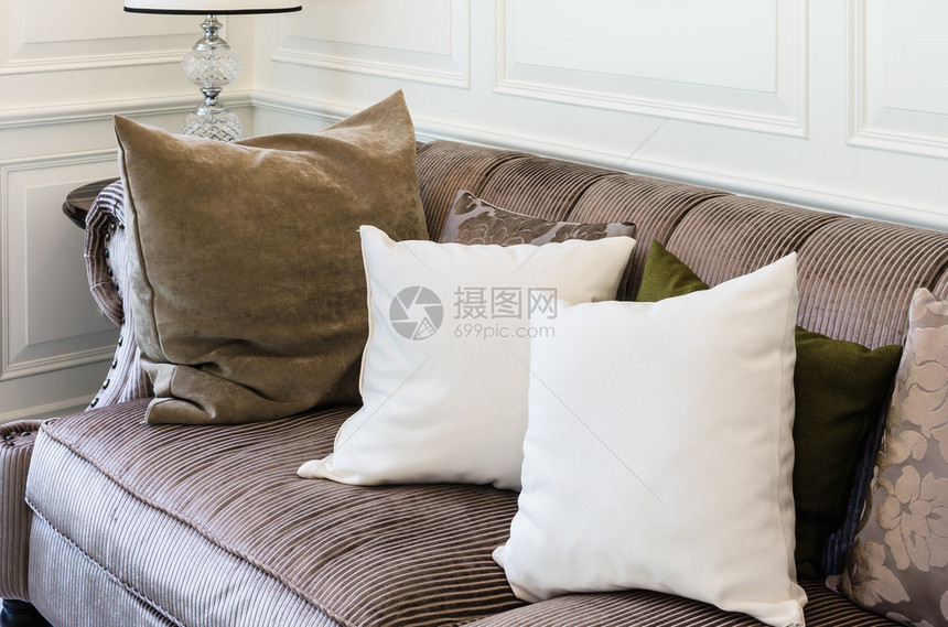 家里客厅棕色沙发上的白色枕头图片