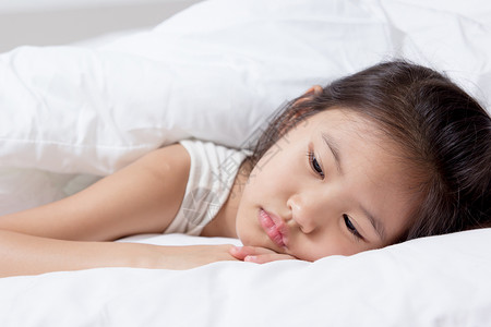亚洲小孩发烧躺在床上图片