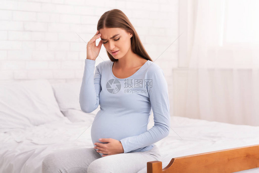 怀孕期间在家中卧床时头戴巾的孕妇头部感到难图片
