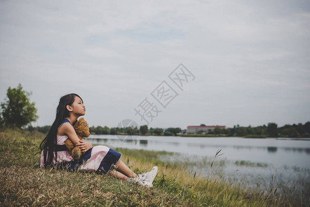 坐在熊旁边的小女孩在草图片