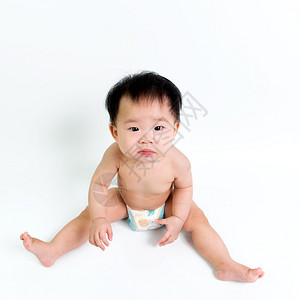 身着尿布的亚洲婴儿坐背景图片