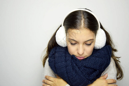 颤抖的年轻女子因流感或冒而低头戴着耳罩围巾和毛衣的年轻女子感冒图片