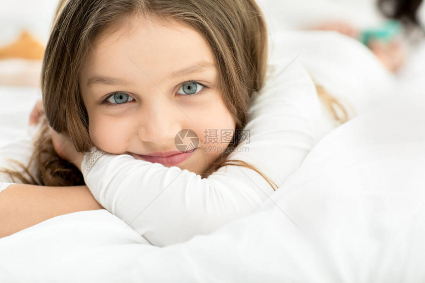 可爱的小女孩躺着在家里床上放松图片