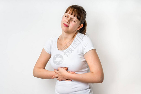 胃痛的女人抱着她的肚子疼孤立图片