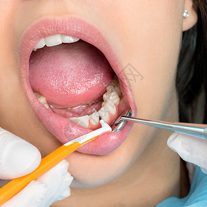 对人类牙齿进行齿间清洁的手特写图片