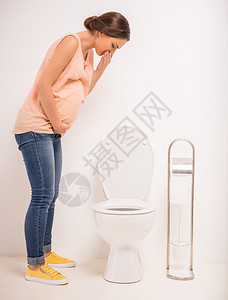 年轻孕妇使用厕所以白色背图片
