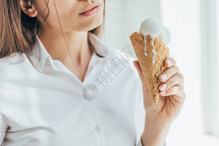 女人在圆锥中拿着融化的冰淇淋的剪影图片