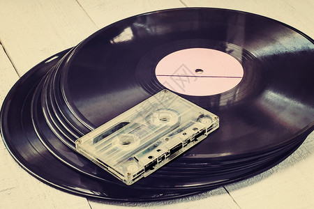 白色木制桌子上的旧黑乙烯胶唱片和录图片