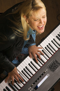 女音乐家一边弹奏数码钢琴一边唱歌图片