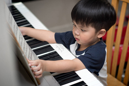 亚洲儿童在家弹钢琴图片
