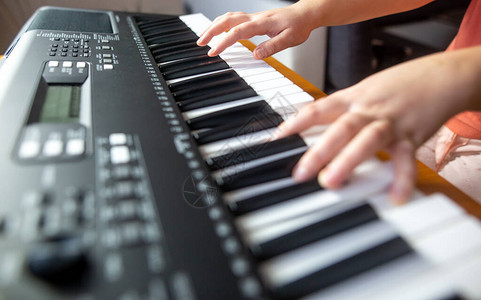 年轻女初学者教自己玩电钢琴演背景图片