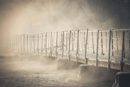 由混凝土块和铁栏杆组成的小老桥在冬季图片