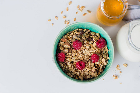 健康早餐含坚果和草莓牛奶和白底的蜂蜜的燕麦面图片