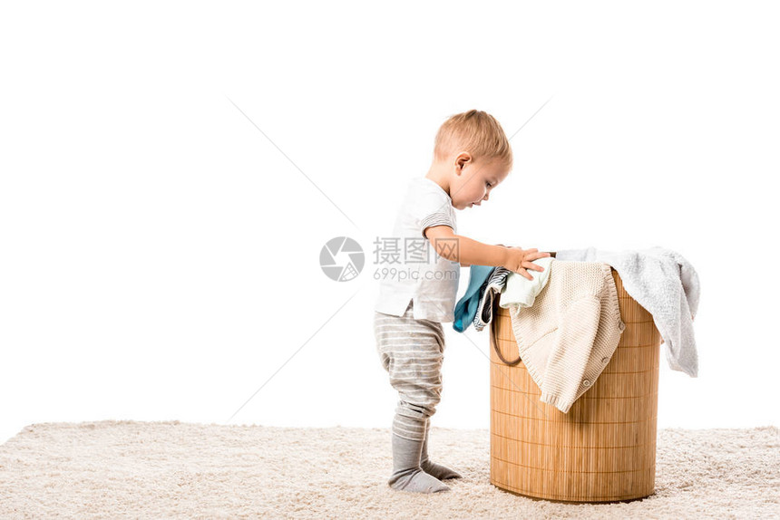 小孩男站在水管洗衣篮前图片