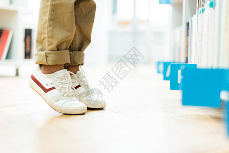 在白色运动鞋上站着脚趾的小孩的作背景图片