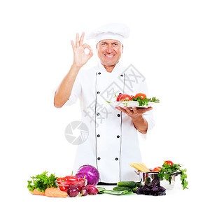 热心的厨师拿着蔬菜盘子并展示好牌子图片