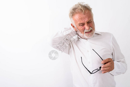 在工作室拍摄有压力的长胡子老人在白色背景下拿着眼镜时颈部疼痛图片