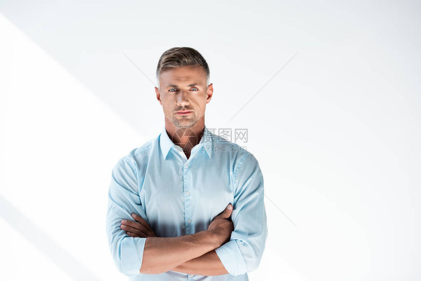 身着衬衫的成年人男子在看镜头时用横臂将图片