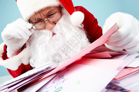 圣诞老人在阅读其中一则信件的图片
