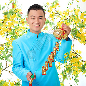 身着传统服装佩戴Tet节装饰的欢乐越南男子图片